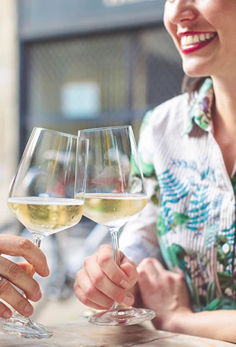 Woman smiling while she is making a toast with someone 