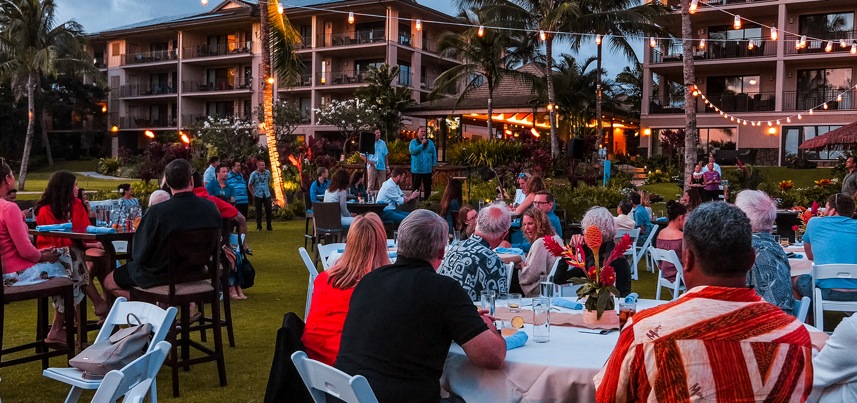 a group of people sitting at tables outside