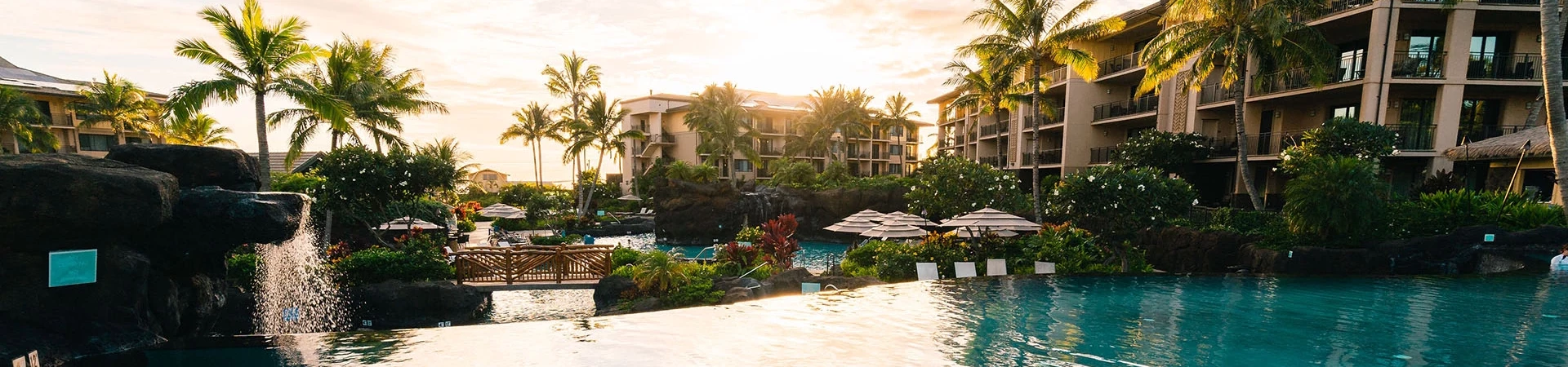 a pool with palm trees and buildings in the background