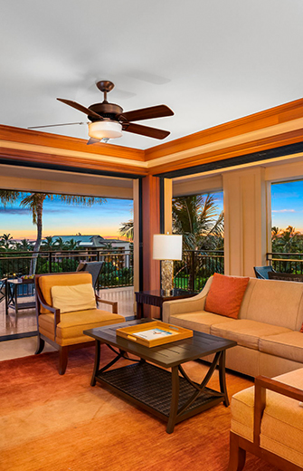 a living room with a ceiling fan and couches