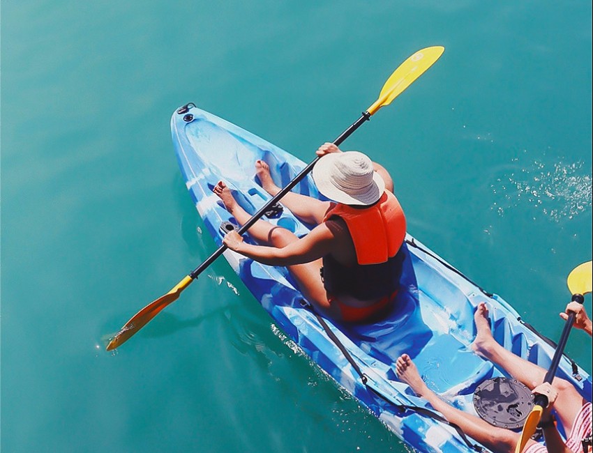 people kayaking in a blue and white colored kayak during the day