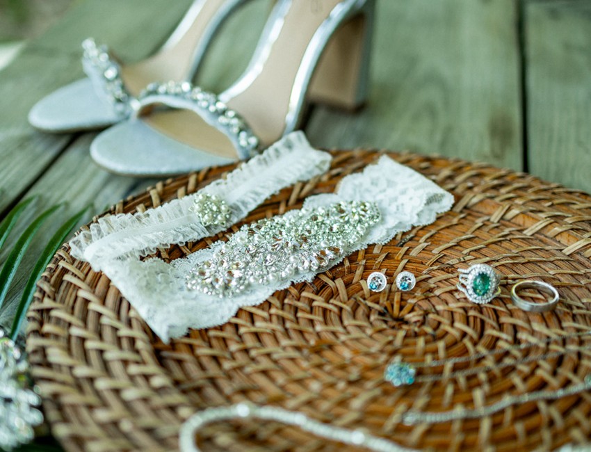 a pair of shoes and garter on a wicker plate
