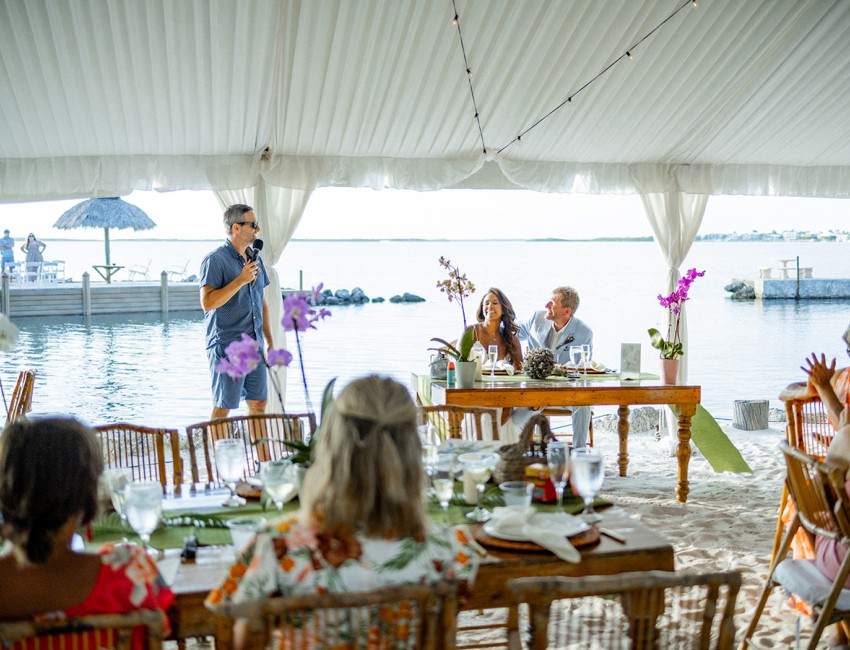 people sitting at tables in a tent
