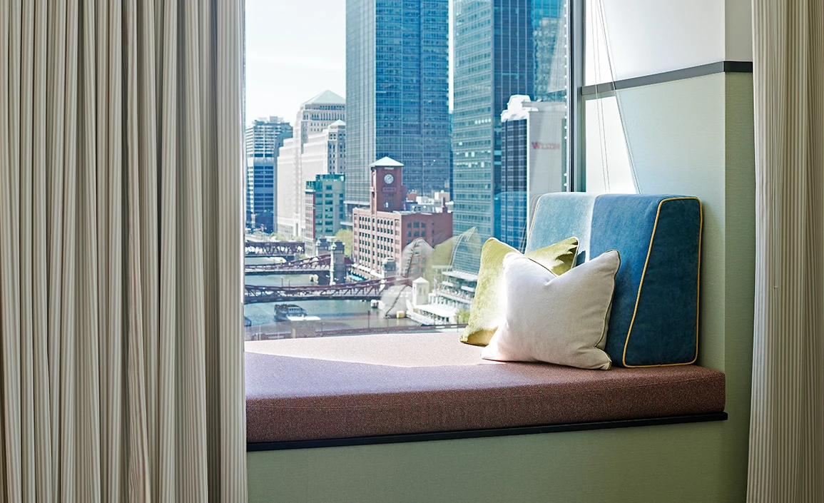 a window seat with pillows and a city view