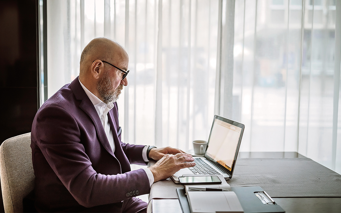 a man in a suit using a laptop