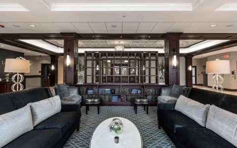 a large room with black couches and a white marble coffee table
