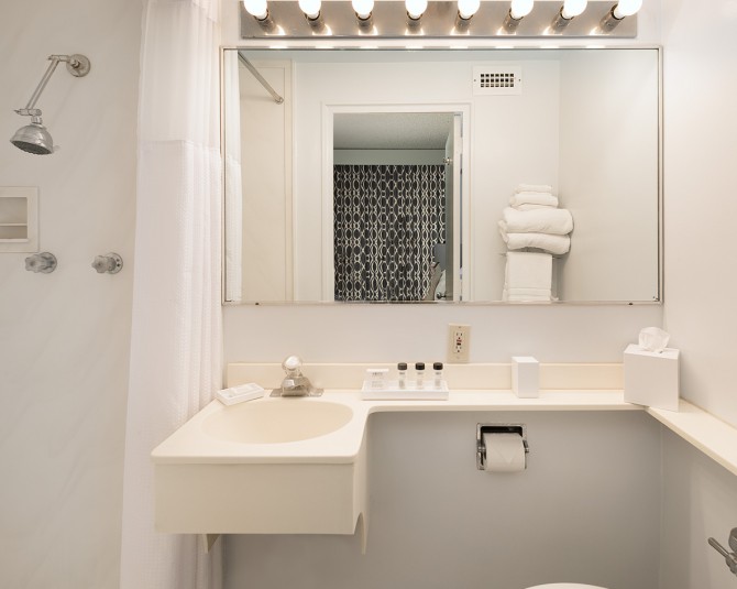 Hotel bathroom vanity with line of decorative bulbs above mirror picture 1