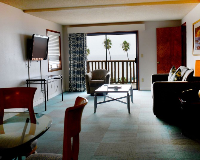hotel room living room with couch, tv and a round dining table picture 1