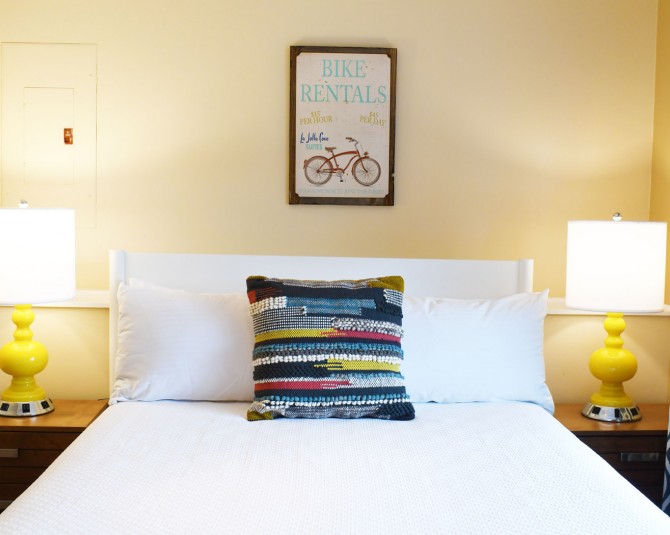 close up of hotel bed with yellow lamps on nightstands picture 0