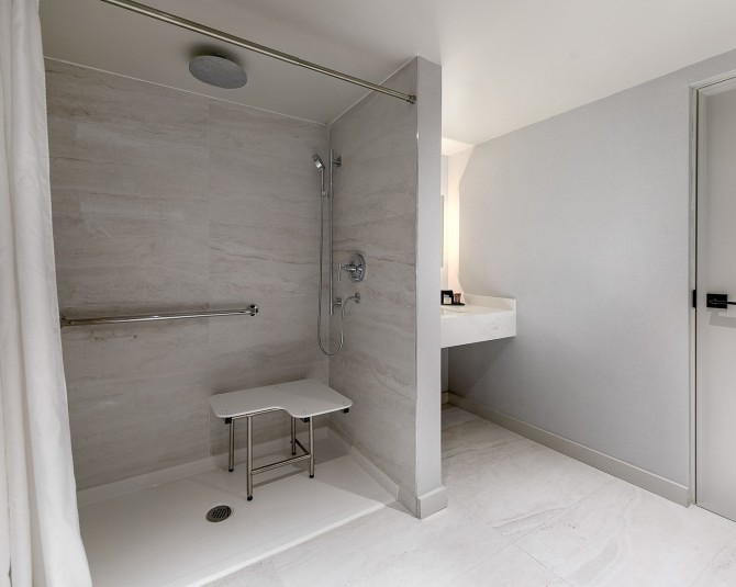 close up of accessible shower with seat and handlebars picture 4