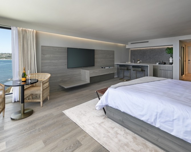 hotel room with king bed, TV, table and 2 chairs, and ocean view picture 2