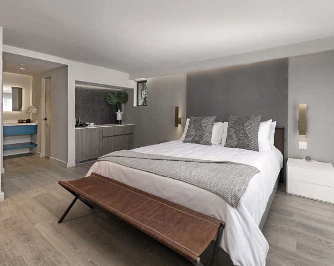 hotel room with king bed and adjacent bathroom picture 0
