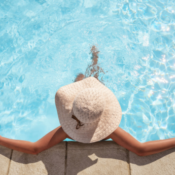a woman in a hat sitting in a pool