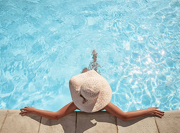 a woman lying on a dock by a pool