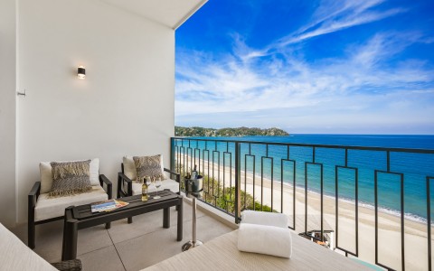 a balcony with a view of the ocean and a beach