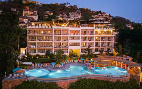 a hotel with a pool and a building in the background