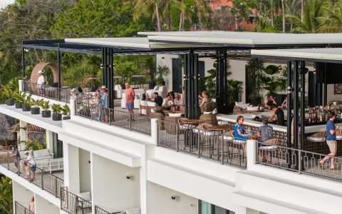 a group of people sitting at tables on a balcony