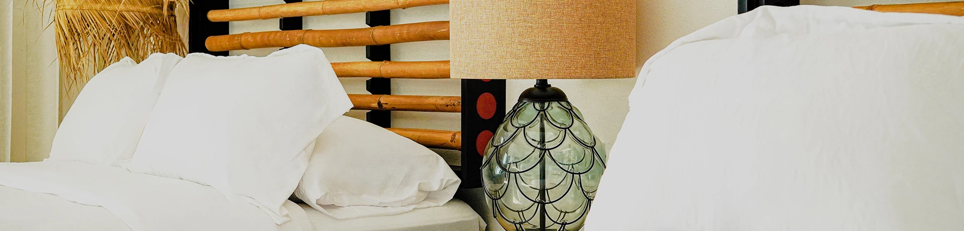a lamp and pillows on a bed