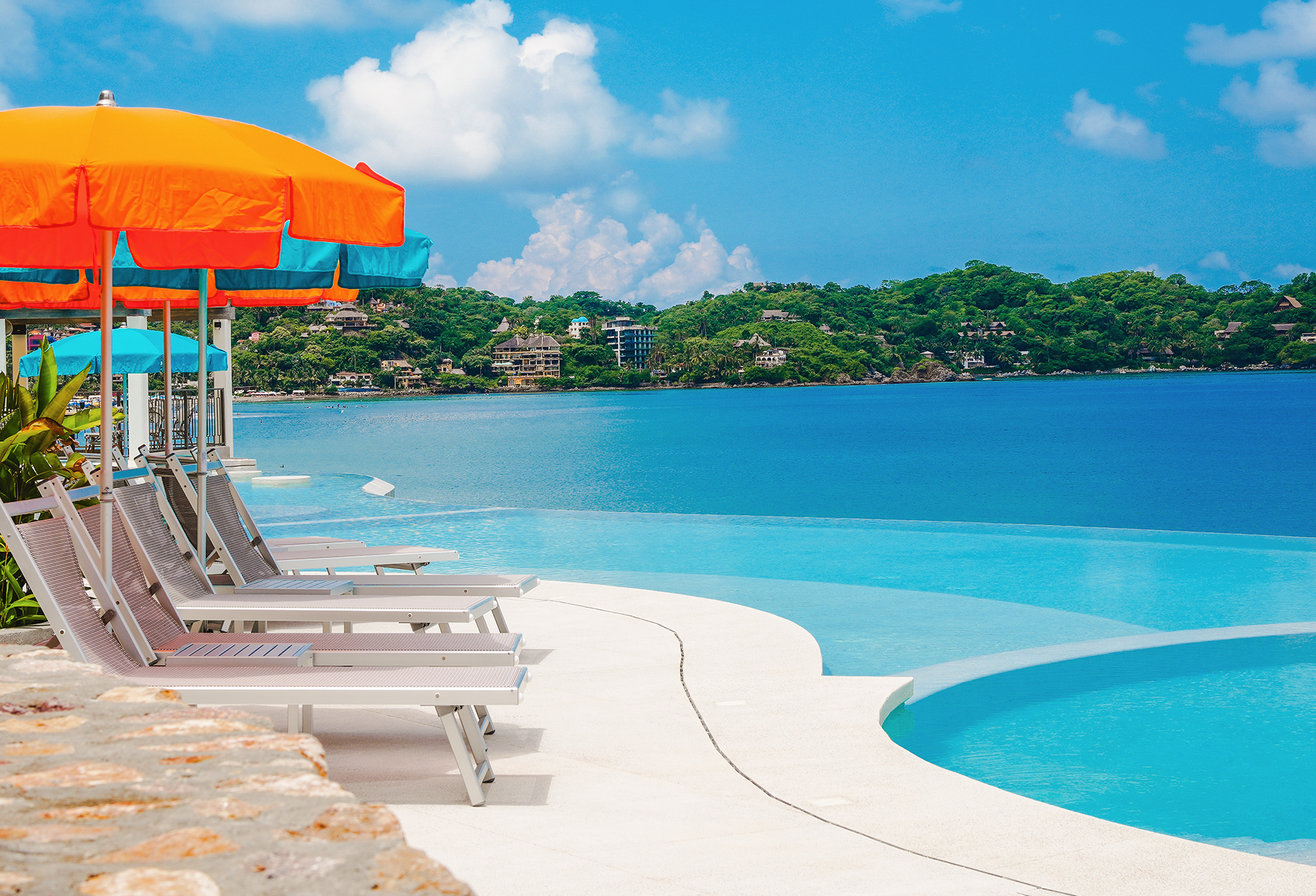 a pool with chairs and umbrellas by it