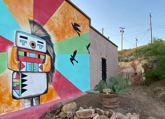 a wall painted with a colorful face and birds