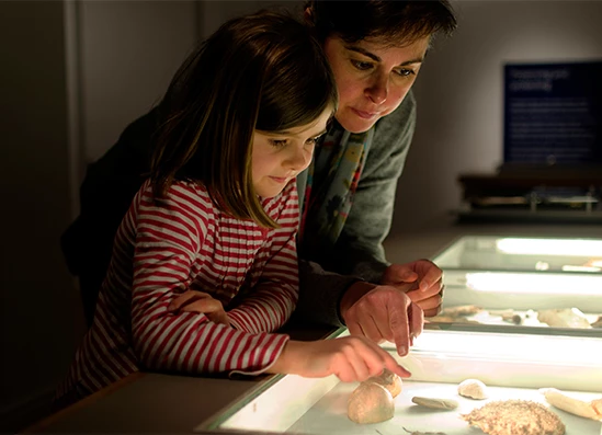 a woman and a girl looking at a display