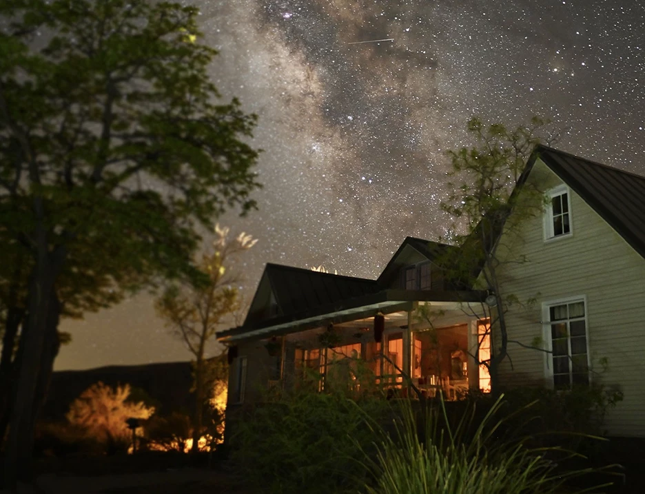 a house with trees and stars in the sky