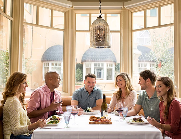 a group of people sitting around a table with food