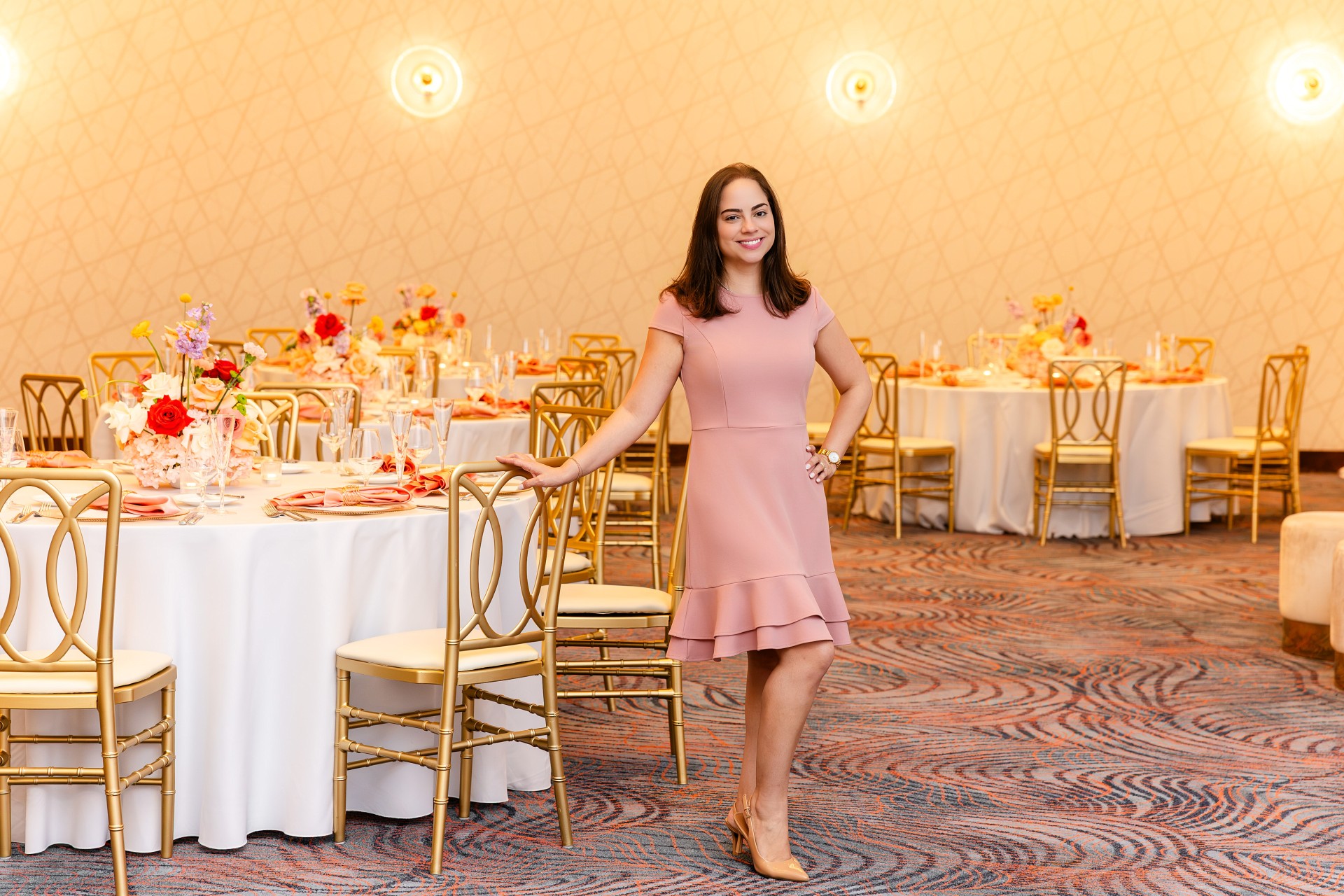 a woman standing in front of a table with chairs and tables