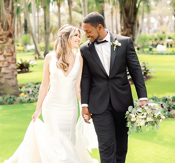 a man and woman in a suit holding hands and smiling