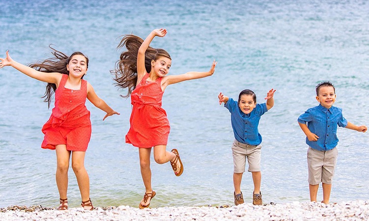 a group of children jumping on a beach