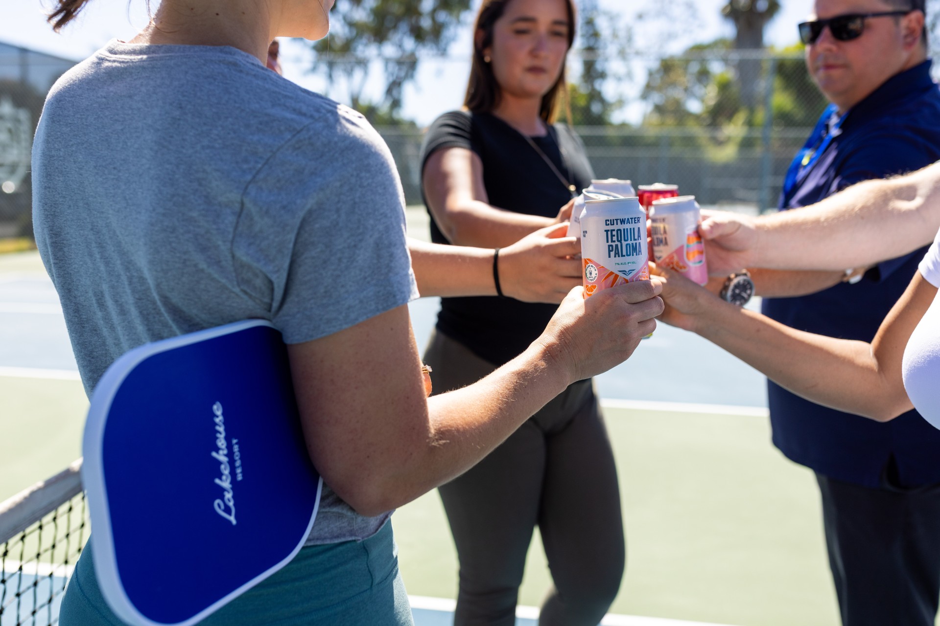 a group of people holding cans of beer