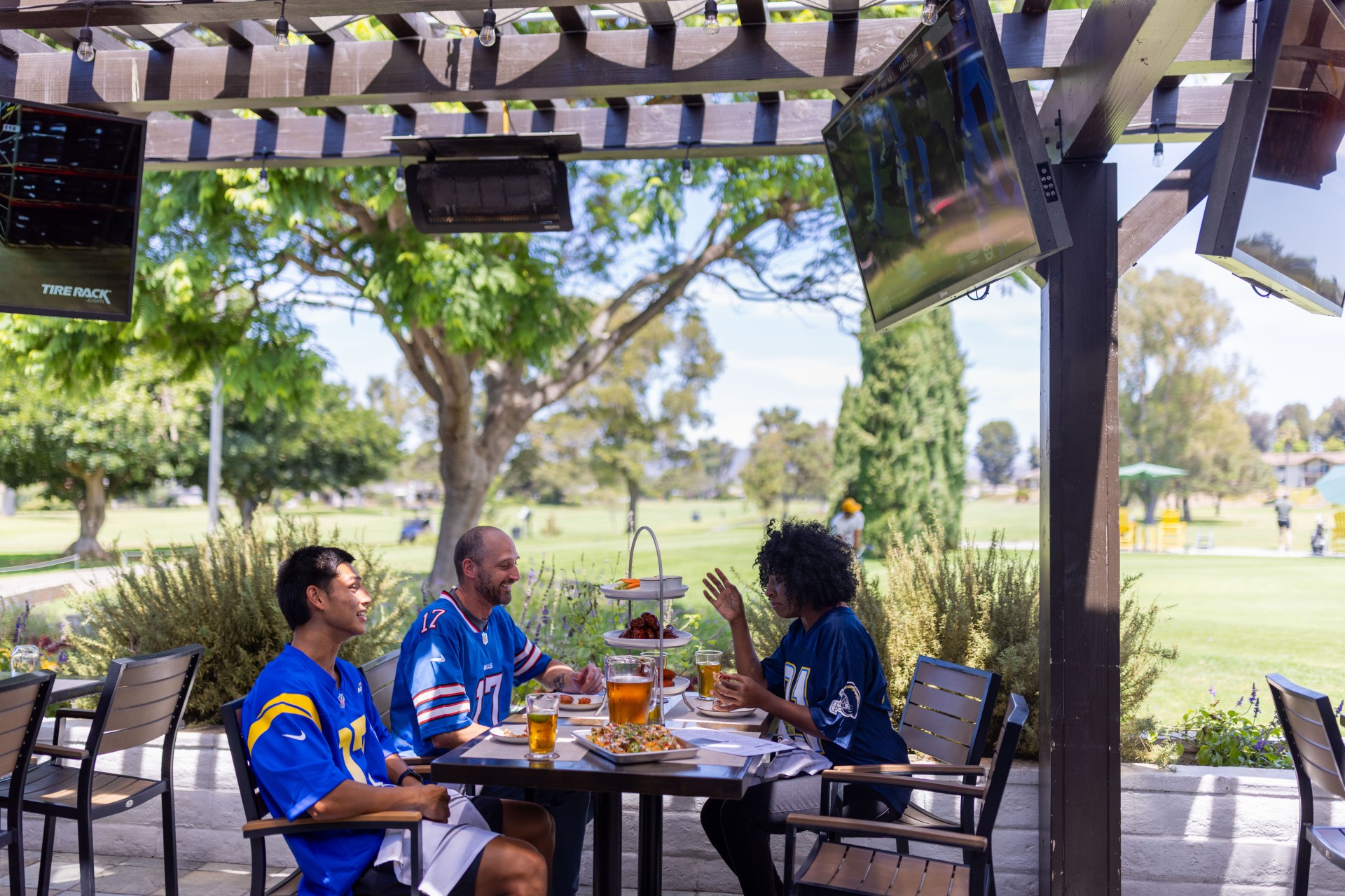 a group of people sitting at a table with food and drinks