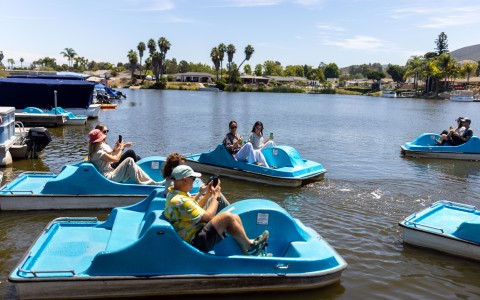 a group of people in pedal boats on a lake