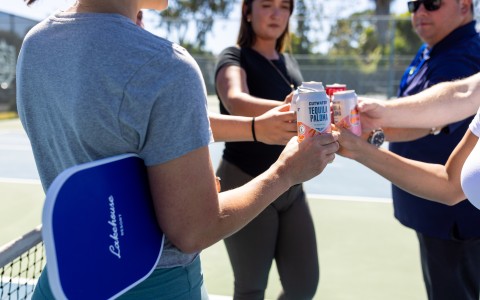a group of people holding cans of beer