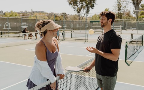 a man and woman standing on a tennis court