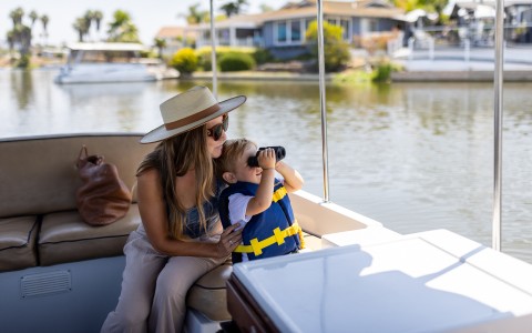 a woman and a child on a boat looking through binoculars