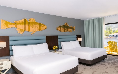 a room with two beds and a fish on the wall