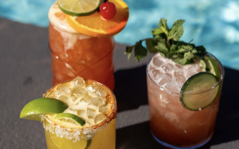 a group of drinks next to a pool