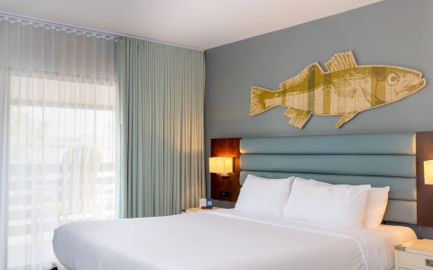 a bed with a large fish on the wall