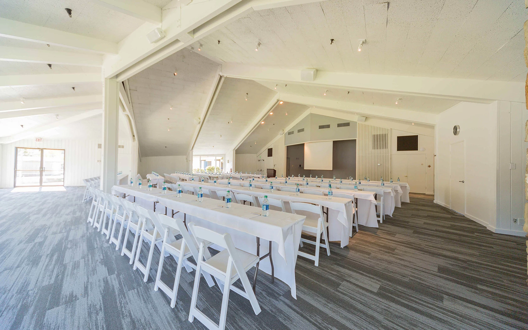 a room with white tables and chairs