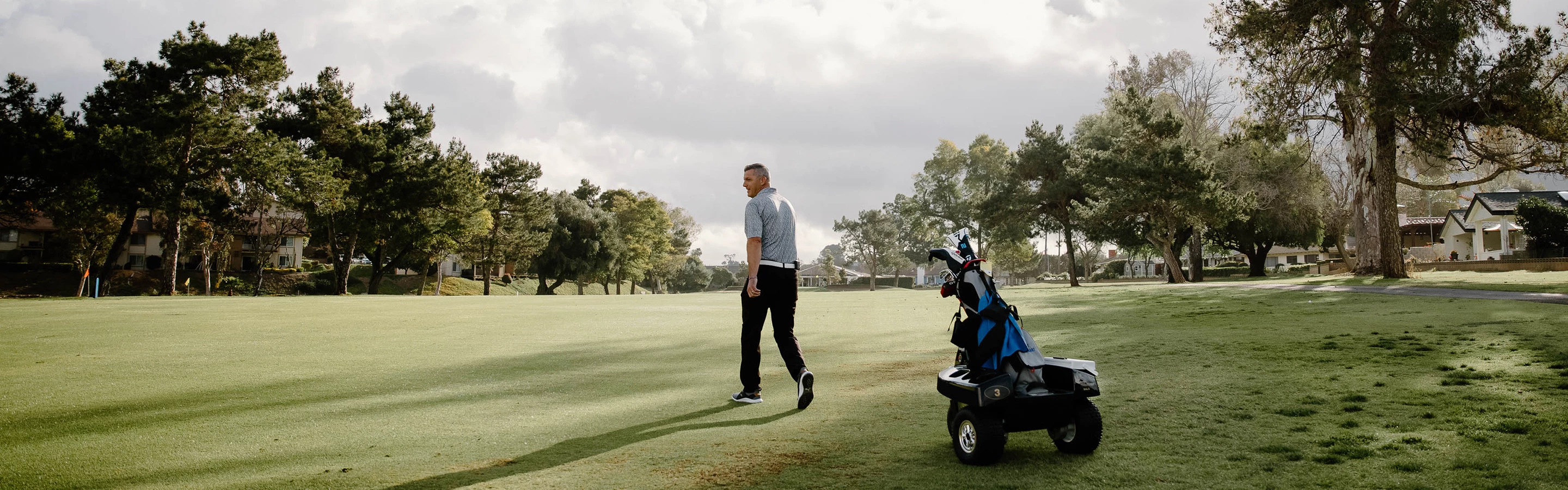 a man walking with a golf cart