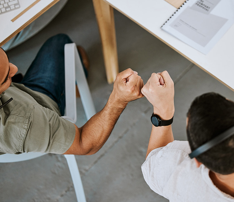 a man sitting at a desk with his hands up