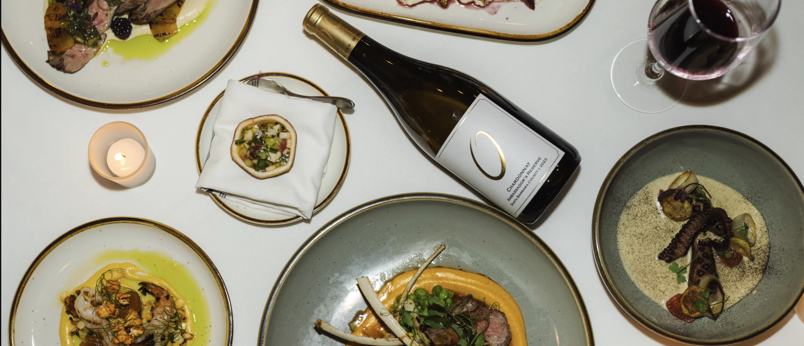 a bottle of wine next to plates of food