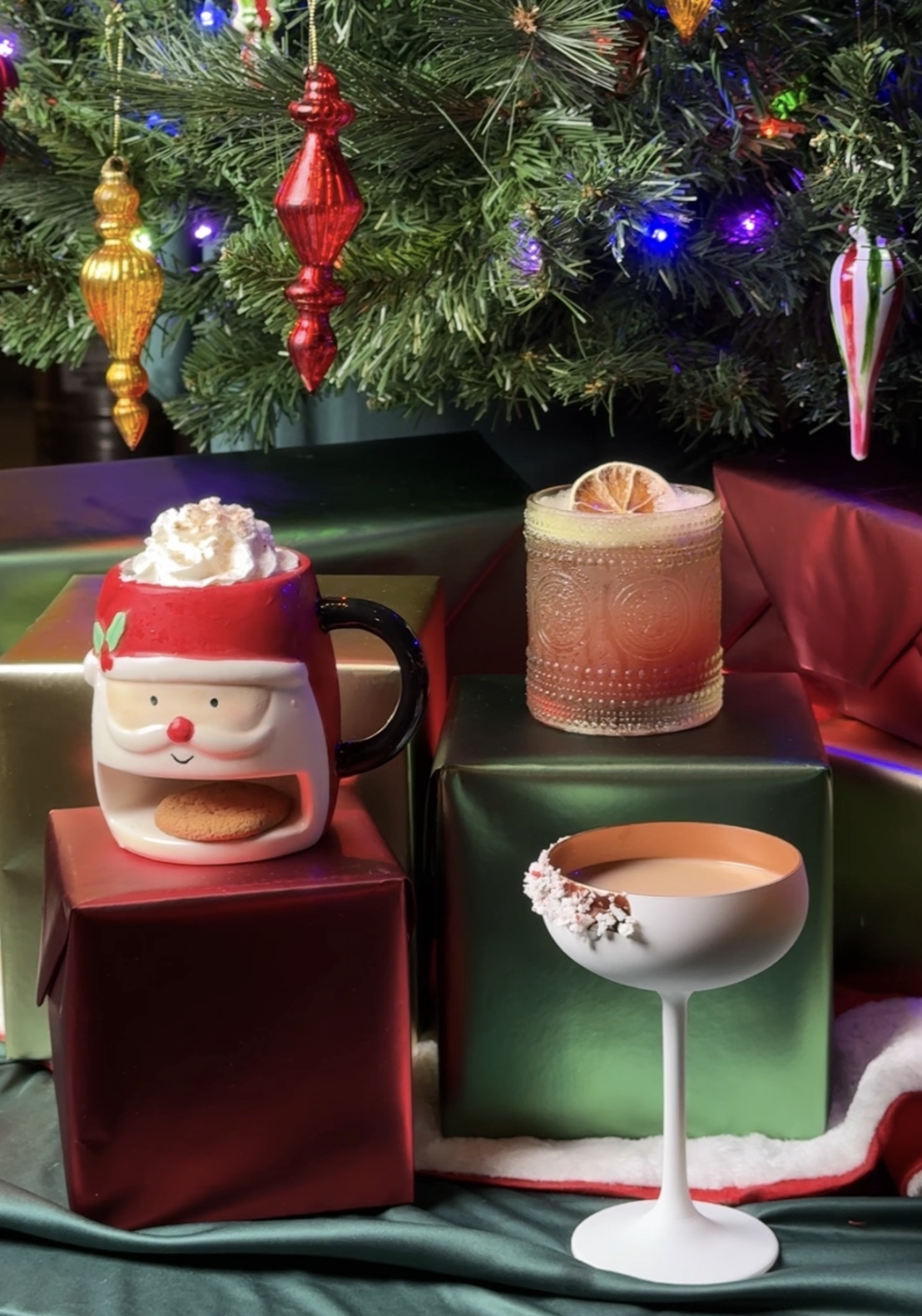 a mug with whipped cream and a drink next to presents
