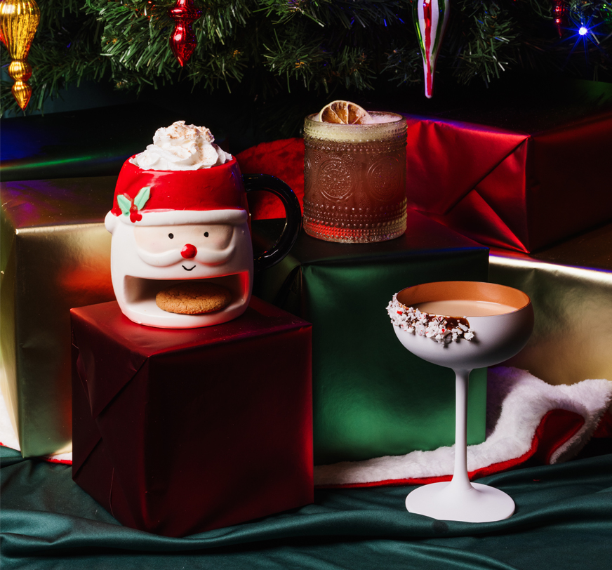 a mug with a cookie and a drink next to a glass of liquid