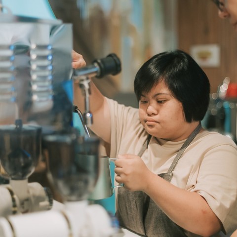 a woman working at a coffee machine