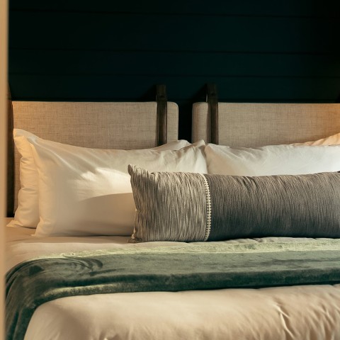a bed with pillows and a green blanket