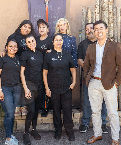 a smiling staff standing in front of las palomas
