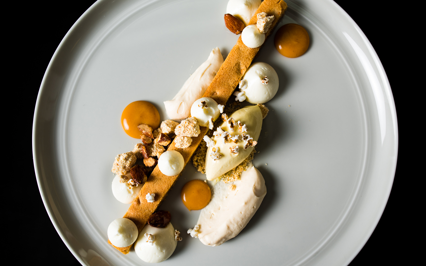 a dessert dish with carmel, creams, and a long thin cake