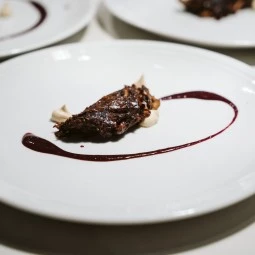 a piece of steak beatifully presented on a white plate 